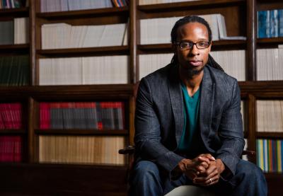 Dr. Ibram Kendi sitting in front of a book shelf