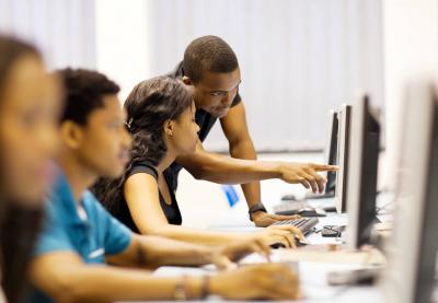 teacher helping student with computer