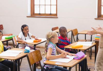 elementary teacher talking with students