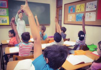 Classroom image with kid raising hand