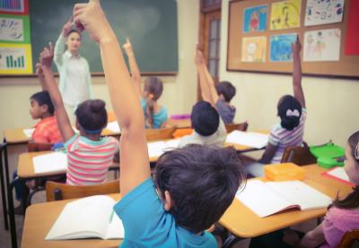 Students raising their hands in class