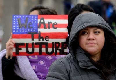 Woman at rally holding sign with caption "We Are the Future"