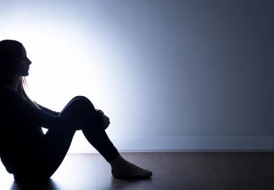 Sitting student silhouetted against light