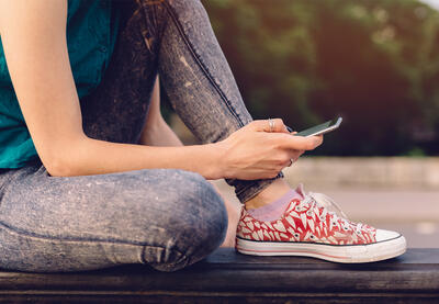 Person wearing red sneakers checking their phone