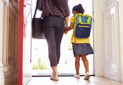 Adult and child walking through door to the outside