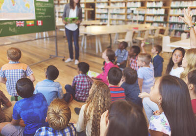 Young student raising hand to ask question during class lecture