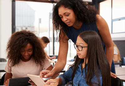 Teacher looking over student's shoulder