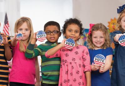 Young kids holding Vote buttons