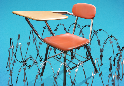 Barbed wire fence surrounding a school desk.