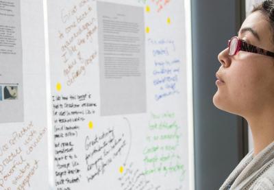 Educator looking at wall of notes.