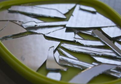 A shattered mirror within its green frame.