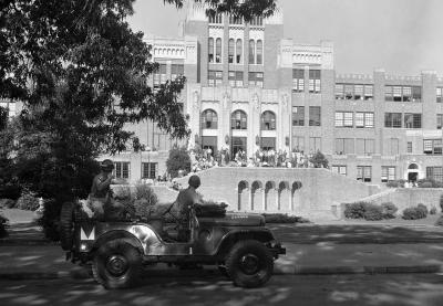 Members of the Arkansas National Guard looking on as students gather outside of the entrance of Little Rock High School.