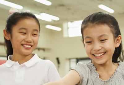 Two young Asian students smiling.