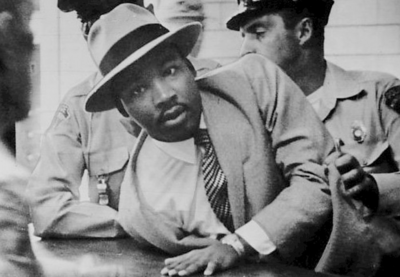 Dr. Martin Luther King, Jr. being detained and arrested by uniformed police officers.