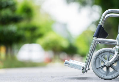 Empty wheelchair parked on what appears to be either a sidewalk or road.