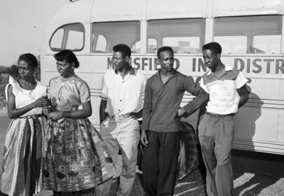 Black students in Mansfield, TX during integration crisis, standing in front of a school bus