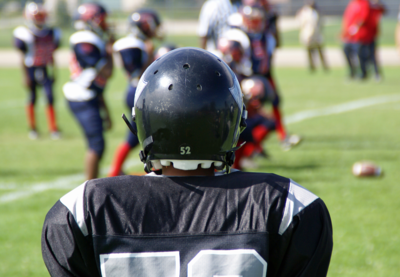 A football player in a uniform with their back to the viewer.