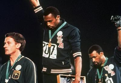 Tommie Smith and John Carlos raise their fists at a 1968 Olympic medal ceremony.