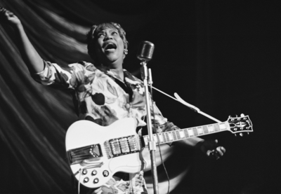 Sister Rosetta Tharpe singing in front of a microphone.