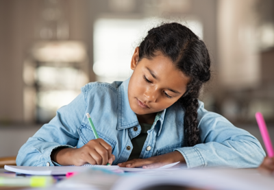 Young child writing in notebook.