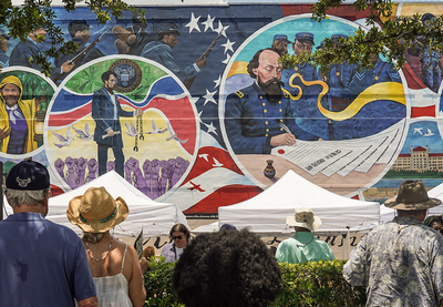 A mural commemorating Juneteenth stretches across the wall of a building. 