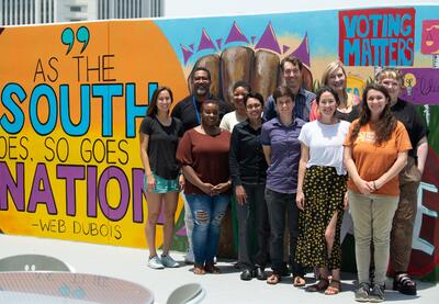 LFJ staff members in front of mural.