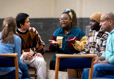 A diverse group of adults meeting in a circle.