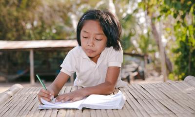 A girl writes in her notebook.