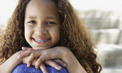 A girl wearing braces smiles at camera