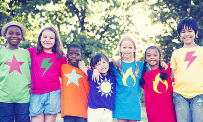 youth in colorful shirts smiling together outdoors