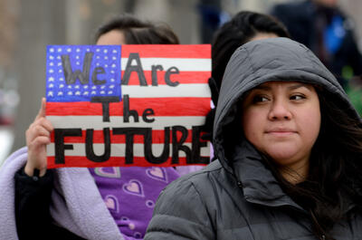 Woman at rally holding sign with caption "We Are the Future"