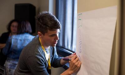 Educator Cody Miller writing on presentation board.