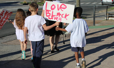 Students marching together holding a Black Lives Matter sign