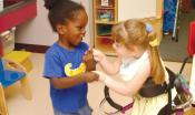 Two children playing. One child has multiple disabilities and the other child does not.