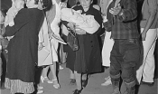 Japanese Americans exit a bus in professional attire. Two women hold babies.