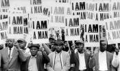 Sanitation workers hold protest signs that say, "I am a man." 