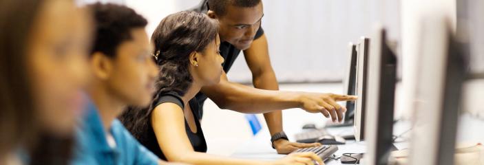 teacher helping student with computer