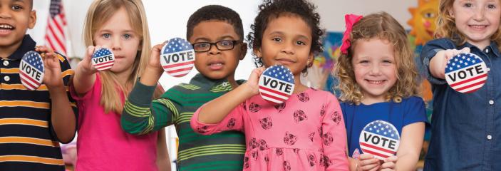 students holding vote buttons