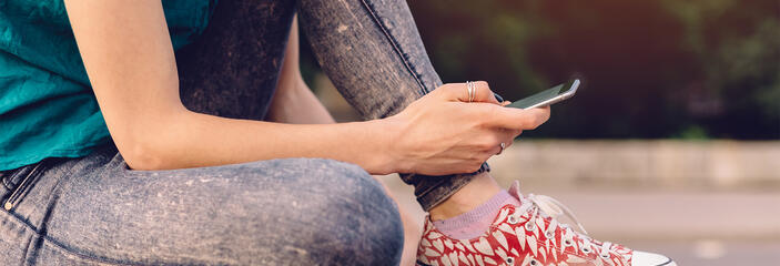 Person wearing red sneakers checking their phone