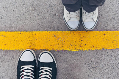 two people standing on yellow line