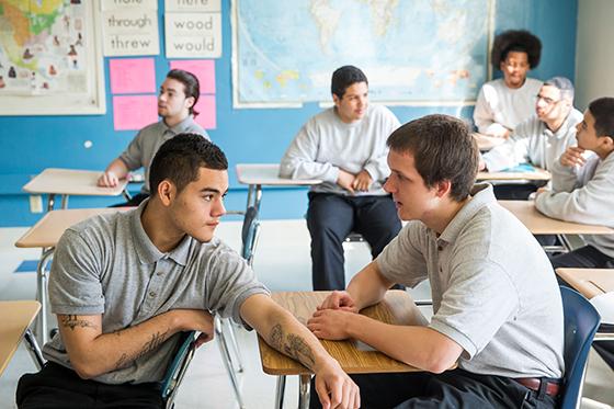 A student talks to his classmate behind him