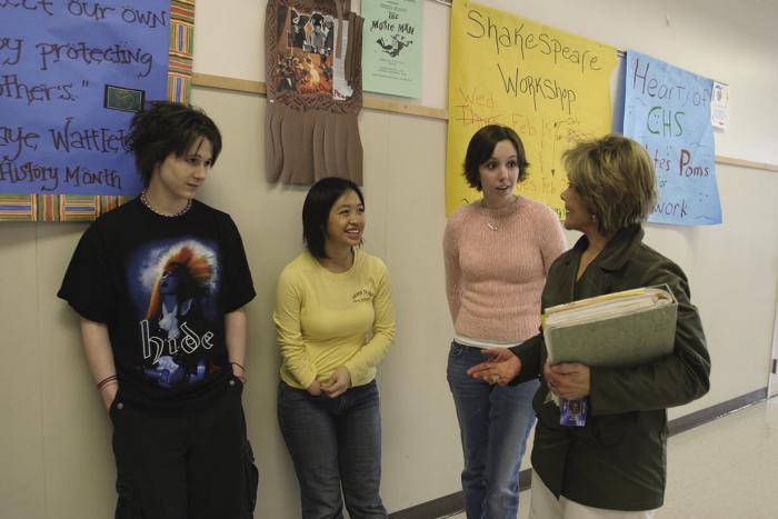 Teacher chatting with three students 