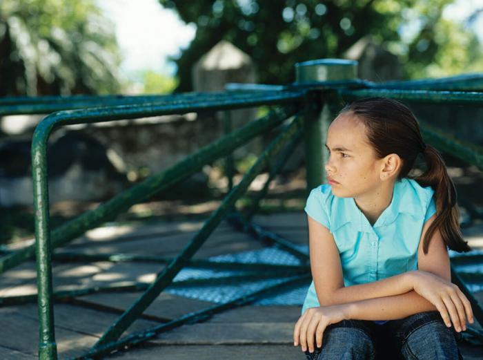 Upset armcrossed young girl on playground