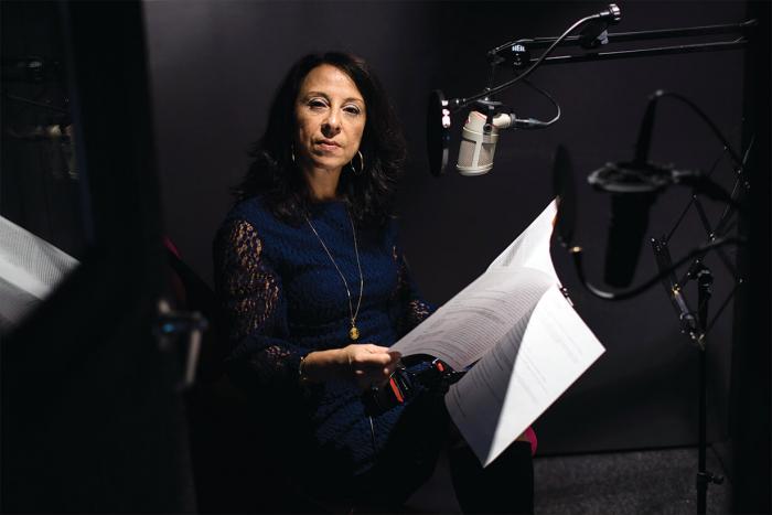 Maria Hinojosa looks over notes as she sits behind radio mic