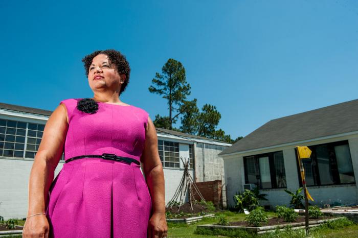 Dr. Susan C. Faircloth, author, standing in front of a school garden