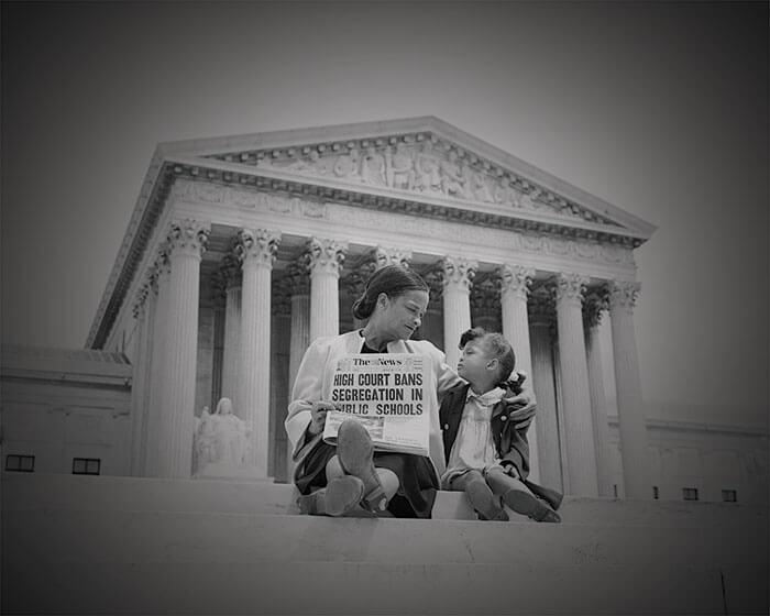 A mother and child sit outside the courthouse steps during Brown vs. Board of Education case