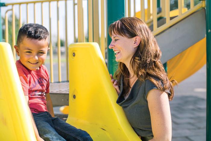 Heidi Sipe watches a student go down the slide