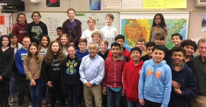 Students in Santa Rosa classroom gathered together for a group photograph with interviewee.