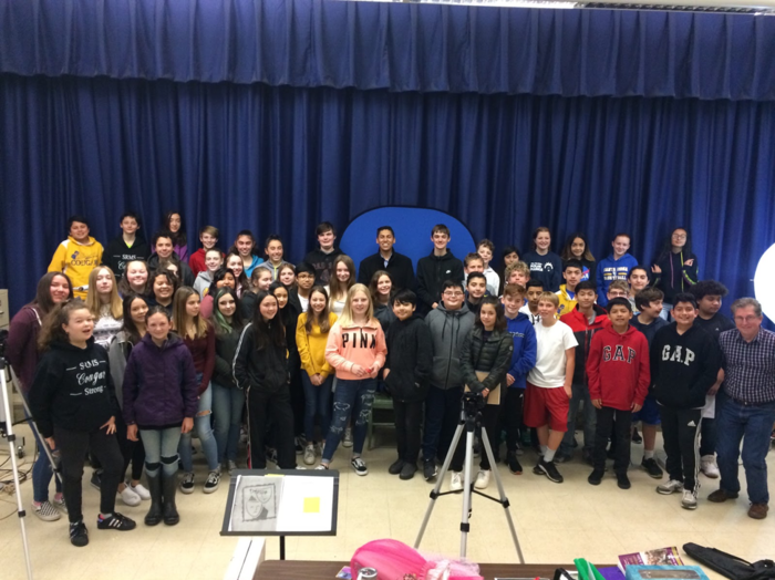 Large group of students gathered together in auditorium for a group photograph.