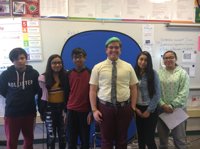 Five students posing for group photo with interviewee.